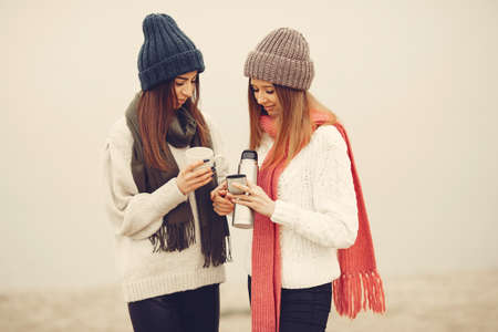 Women in a winter park without snow with bottle and teaの写真素材