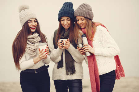 Women in a winter park without snow with bottle and teaの写真素材