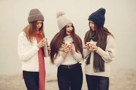 Women in a winter park without snow with bottle and teaの写真素材