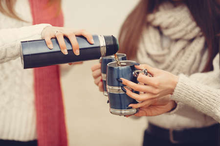 Women in a winter park without snow with bottle and teaの写真素材