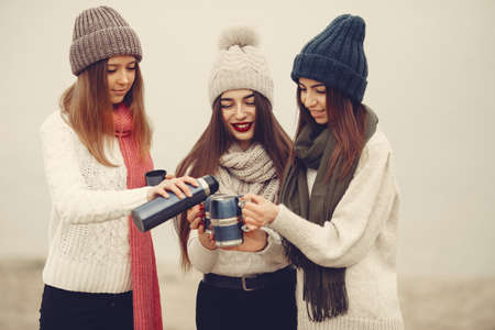 Women in a winter park without snow with bottle and teaの写真素材