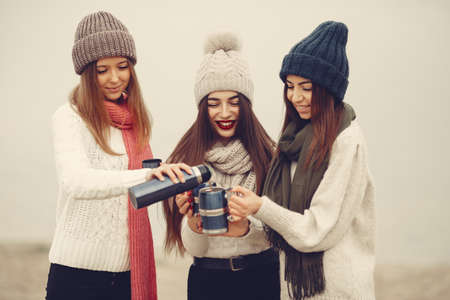 Women in a winter park without snow with bottle and teaの写真素材