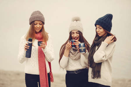 Women in a winter park without snow with bottle and teaの写真素材