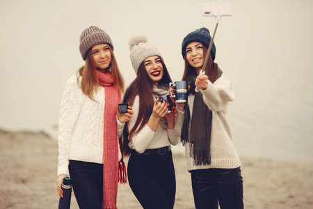 Women in a winter park without snow with bottle and teaの写真素材