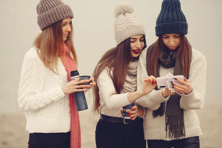 Women in a winter park without snow with bottle and teaの写真素材