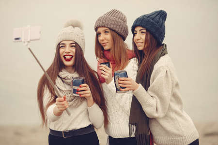 Women in a winter park without snow with bottle and teaの写真素材