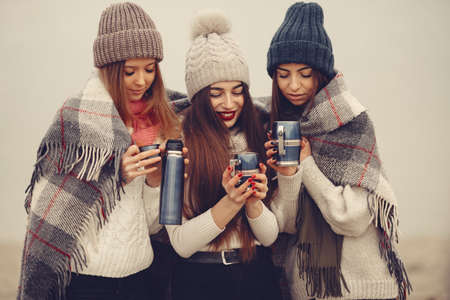 Women in a winter park without snow with bottle and teaの写真素材