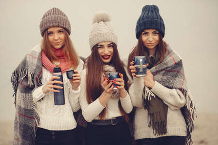 Women in a winter park without snow with bottle and teaの写真素材