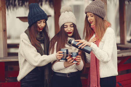 Women in a winter park without snow with bottle and teaの写真素材