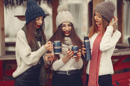 Women in a winter park without snow with bottle and teaの写真素材