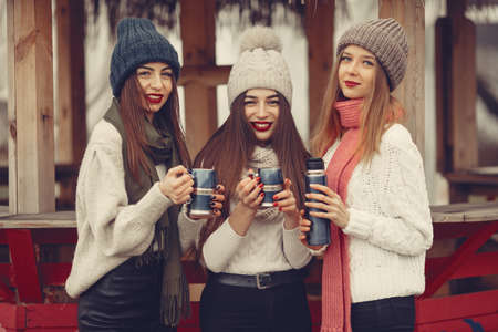 Women in a winter park without snow with bottle and teaの写真素材