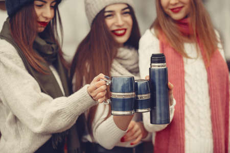 Women in a winter park without snow with bottle and teaの写真素材