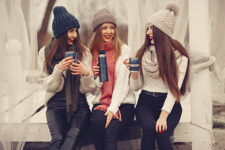 Women in a winter park without snow with bottle and teaの写真素材