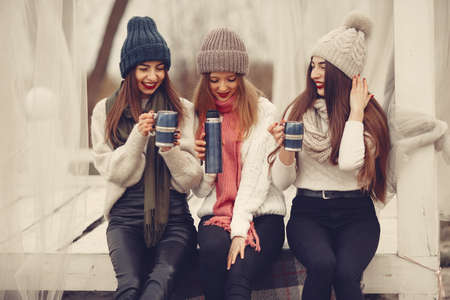 Women in a winter park without snow with bottle and teaの写真素材