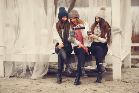 Women in a winter park without snow with bottle and teaの写真素材