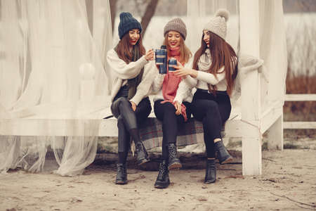 Women in a winter park without snow with bottle and teaの写真素材
