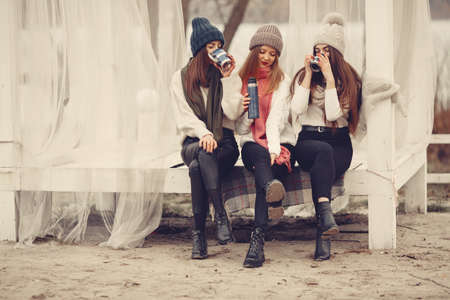 Women in a winter park without snow with bottle and teaの写真素材