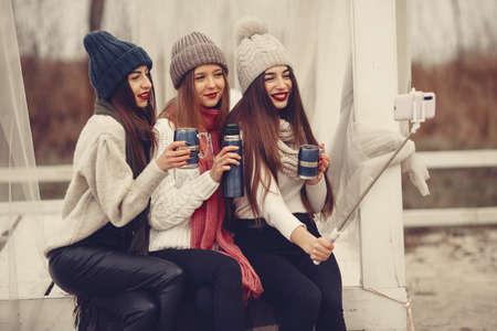 Women in a winter park without snow with bottle and teaの写真素材