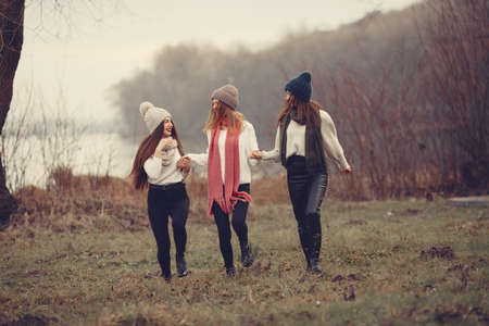 Thre friends walks in a winter park without snowの写真素材