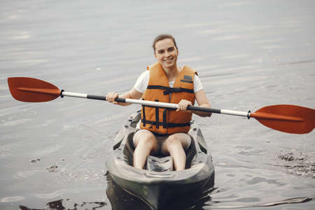 Woman paddling on a lake in a kayakの写真素材