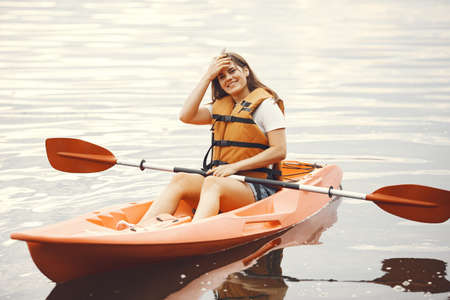 Woman paddling on a lake in a kayakの写真素材