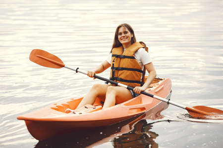 Woman paddling on a lake in a kayakの写真素材