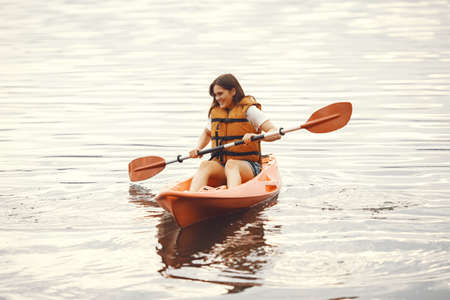 Woman paddling on a lake in a kayakの写真素材