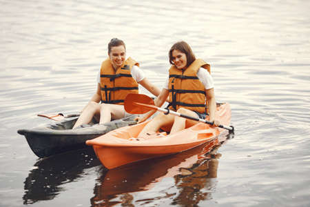 Women paddling on a lake in a kayakの写真素材