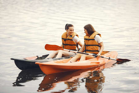 Women paddling on a lake in a kayakの写真素材