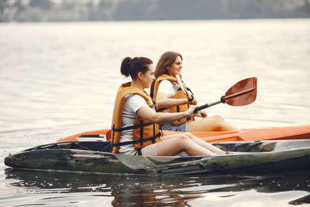 Women paddling on a lake in a kayakの写真素材