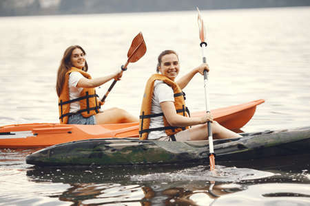 Women paddling on a lake in a kayakの写真素材