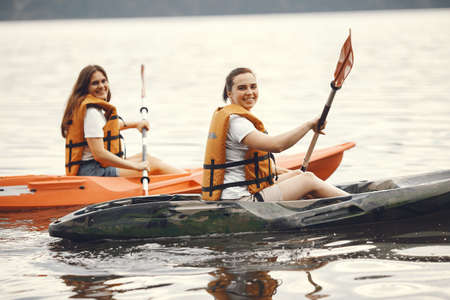 Women paddling on a lake in a kayakの写真素材