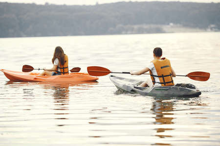 Women paddling on a lake in a kayakの写真素材