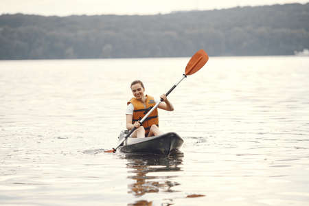 Woman paddling on a lake in a kayakの写真素材