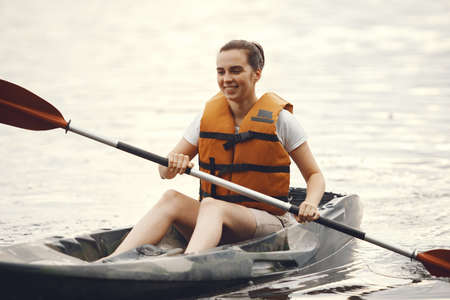 Woman paddling on a lake in a kayakの写真素材