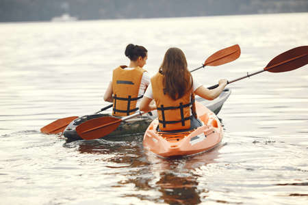 Women paddling on a lake in a kayakの写真素材