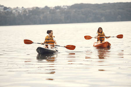 Women paddling on a lake in a kayakの写真素材