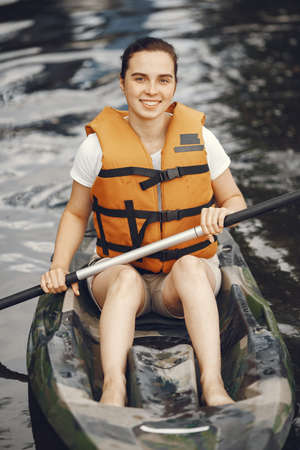 Woman paddling on a lake in a kayakの写真素材