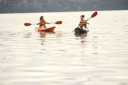 Women paddling on a lake in a kayakの写真素材