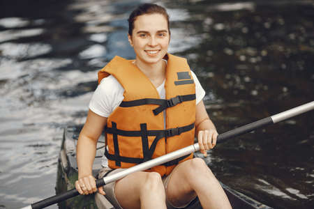 Woman paddling on a lake in a kayakの写真素材