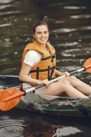 Woman paddling on a lake in a kayakの写真素材