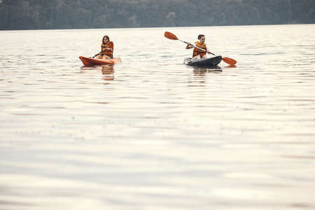Women paddling on a lake in a kayakの写真素材