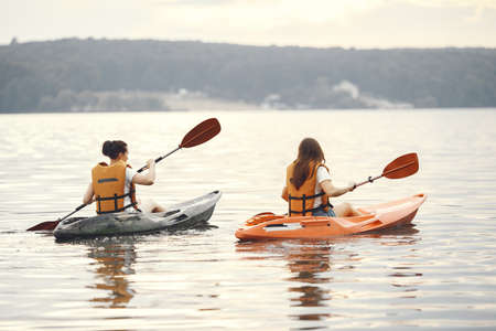 Women paddling on a lake in a kayakの写真素材