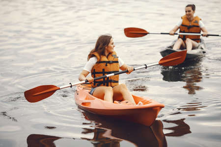 Women paddling on a lake in a kayakの写真素材