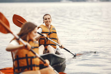 Women paddling on a lake in a kayakの写真素材