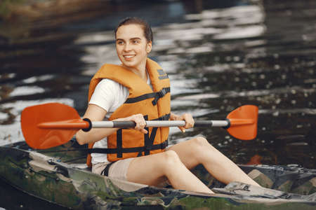 Woman paddling on a lake in a kayakの写真素材