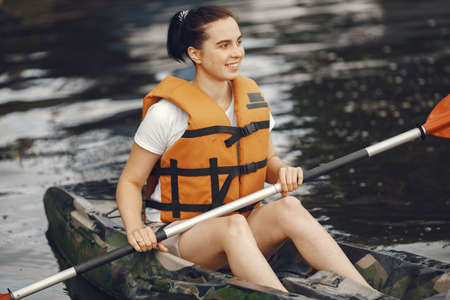 Woman paddling on a lake in a kayakの写真素材