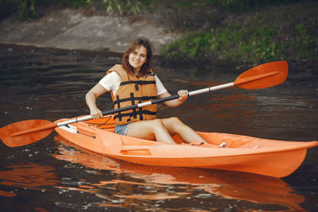 Woman paddling on a lake in a kayakの写真素材
