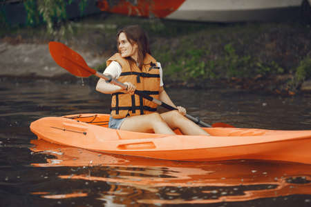Woman paddling on a lake in a kayakの写真素材
