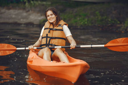 Woman paddling on a lake in a kayakの写真素材